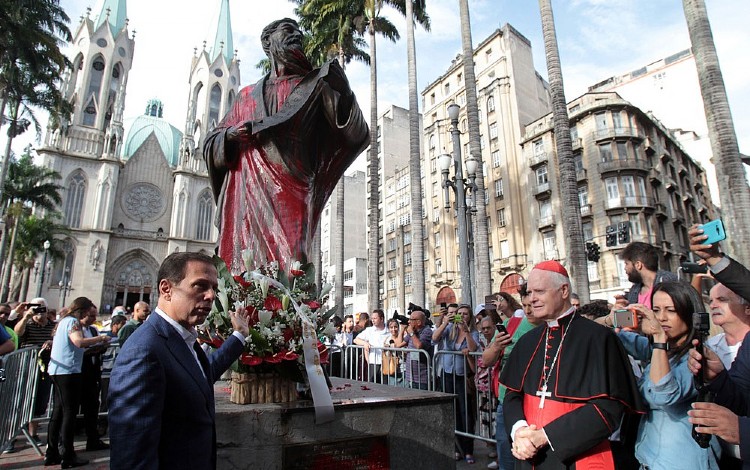 O prefeito João Doria mostra a estátua do apóstolo Paulo que foi pintada de vermelho na Praça da Sé (Foto: Felipe Rau)