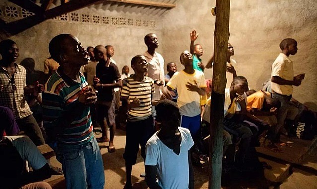 Imagem ilustrativa. Jovens africanos durante noite de oração num pobre vilarejo em Pemba, Moçambique