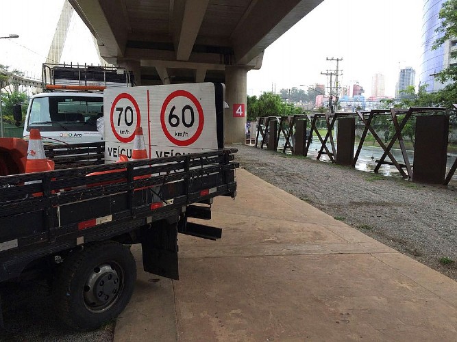 Caminhões estacionados embaixo da Ponte Estaiada com as novas placas da marginal (Foto: Will Soares/G1)