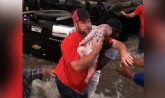 Homem retira o bebê desacordado do carro que estava preso na correnteza (Foto: Reprodução/Facebook)